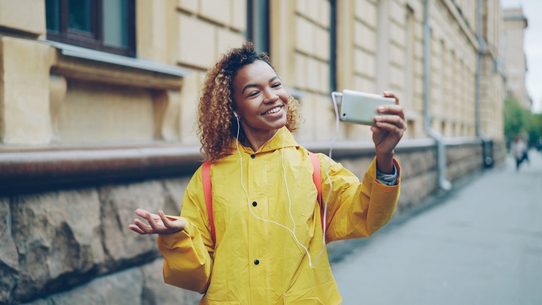 Young woman taking a selfie on a city street.